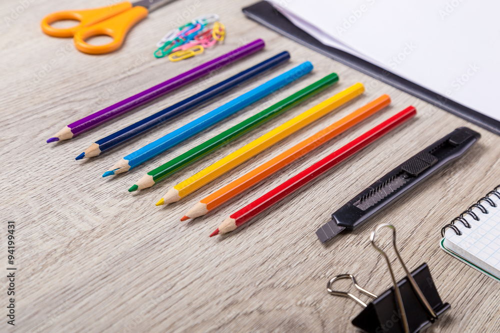Obraz premium Paper, pencils, brush, green apple on wooden table