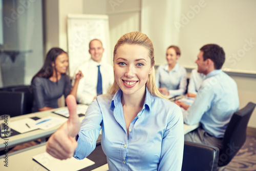 group of smiling businesspeople meeting in office