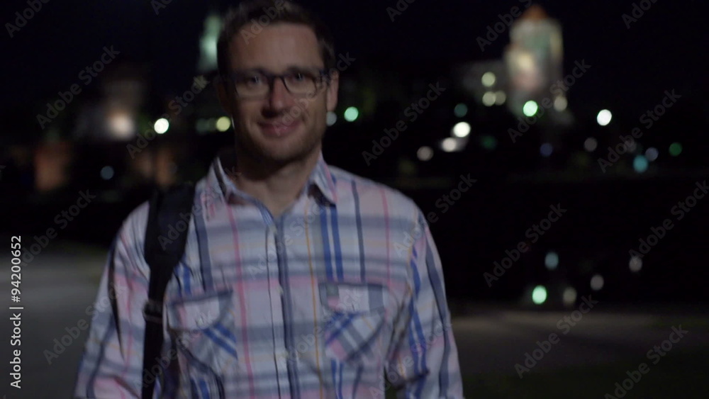 Man walking at nigth with a bad and smiling to the camera, steadycam shot
Man walking at nigth with a bad and smiling to the camera, steadycam shot