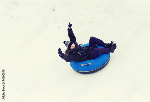 happy young man sliding down on snow tube