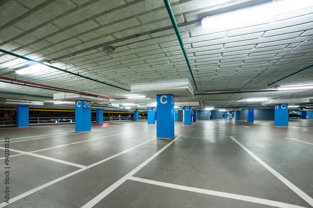 empty grey parking with colored blue columns without cars