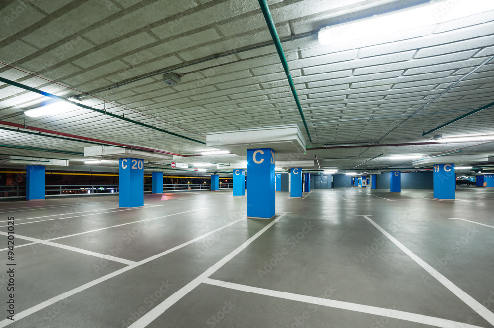 empty grey parking with colored blue columns without cars empty grey parking with colored blue columns without cars