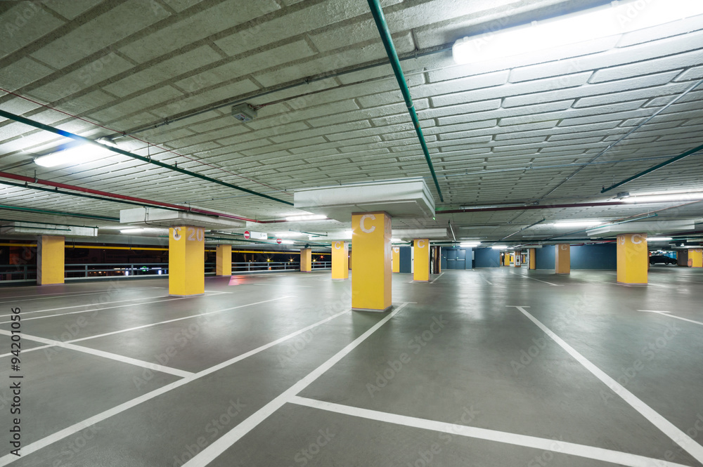 empty grey parking with colored yellow columns without cars