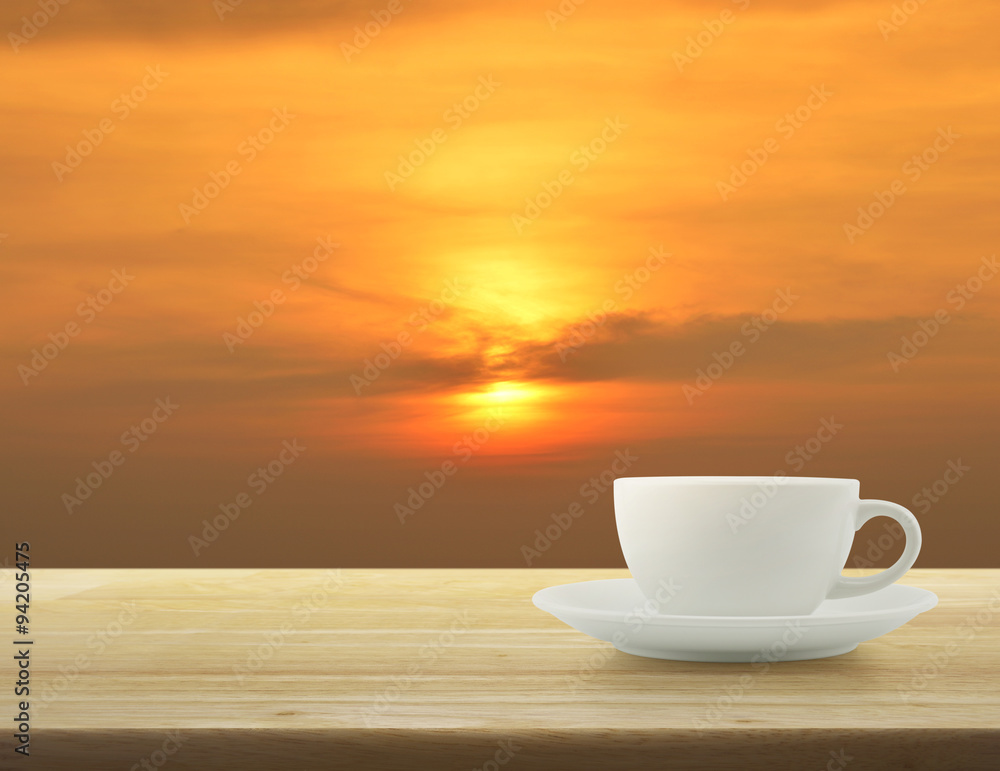 Obraz premium White cup on wooden table over sky