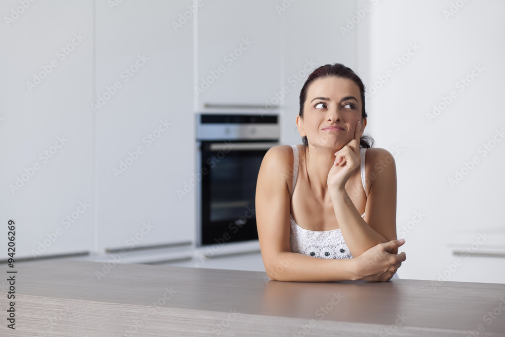Young woman is sitting in the kitchen Young woman is sitting in the kitchen