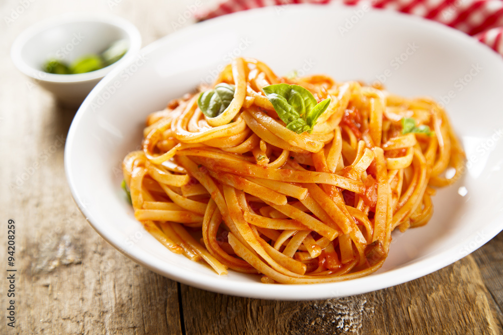 Pasta with vegetable sauce and green basil