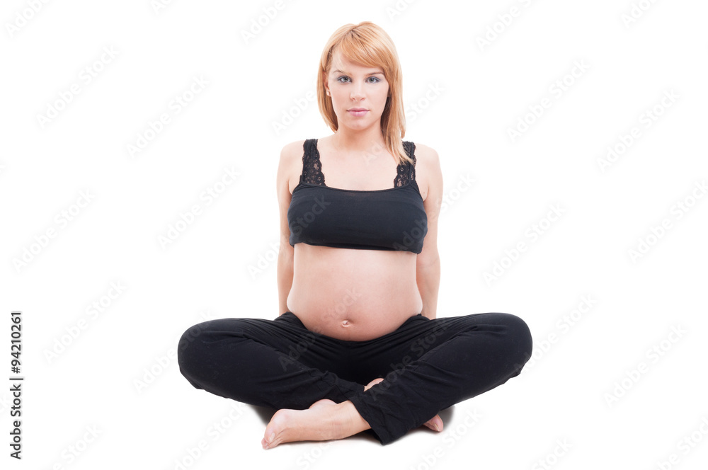 Beautiful young pregnant woman sitting isolated on white