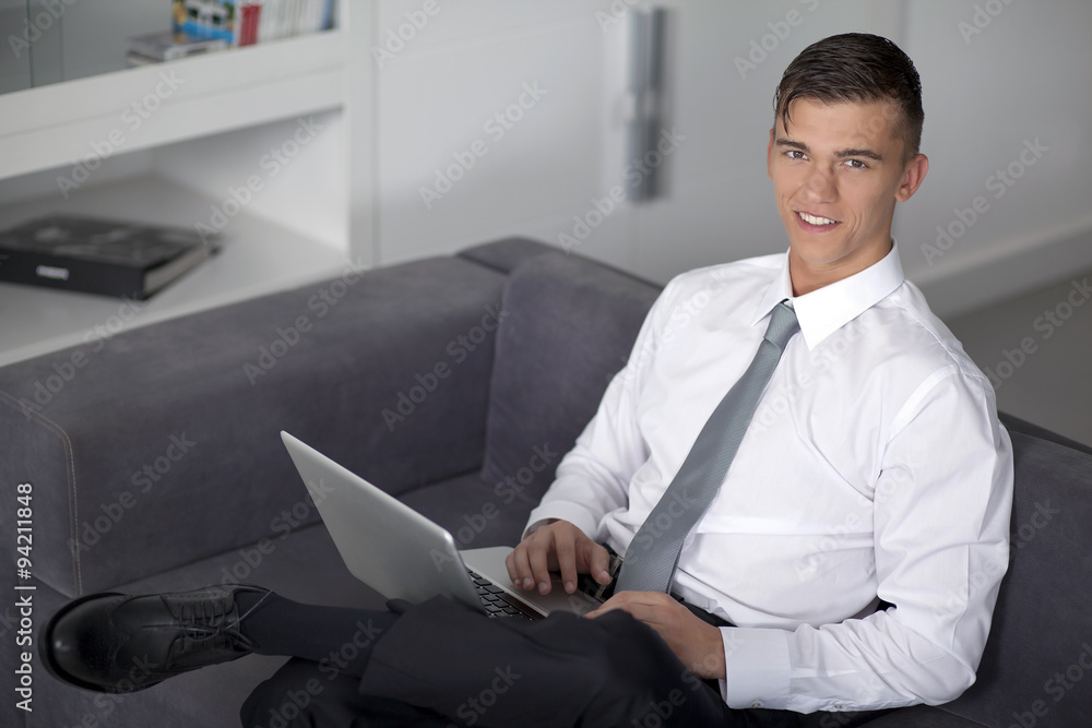 Successfull businessman working with a notebook and sitting on c
