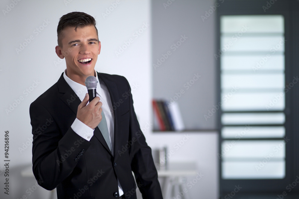 Successful businessman singing with a microphone in office Successful businessman singing with a microphone in office