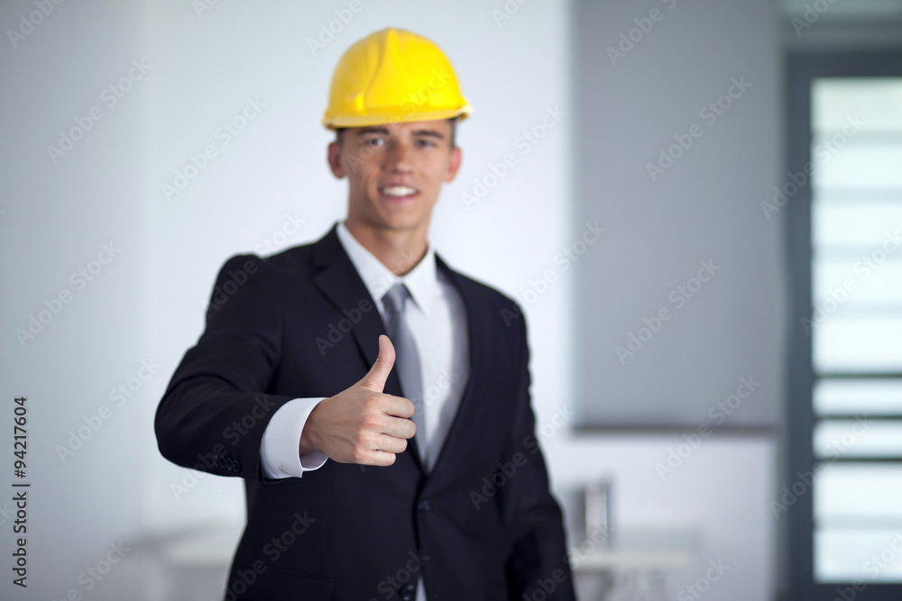 Successful businessman with yellow helmet poses and hand gesturi Successful businessman with yellow helmet poses and hand gesturi