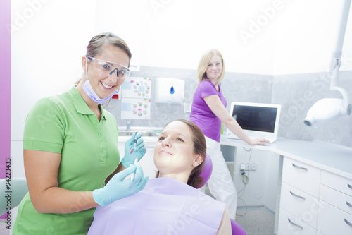 Female dentist starting to work on teeth of woman in a dentist r