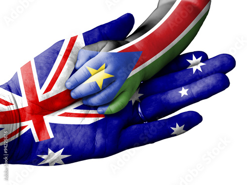 Adult man holding a baby hand with Australia and South Sudan flags overlaid. Isolated on white photo