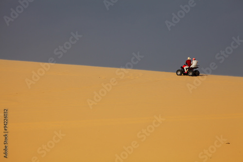 A Couple Riding Quad Bike in Desert