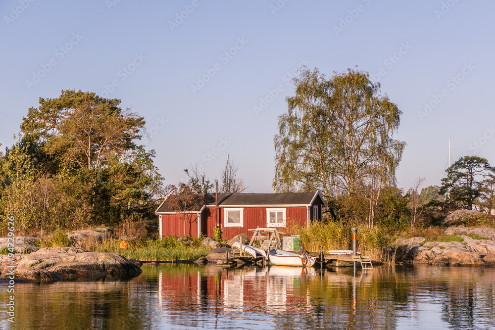 Obraz premium Red cottages and fishing boat near Oxelosund in south Sweden