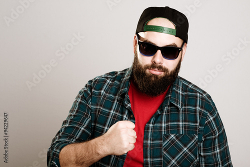 bearded man with baseball cap and sunglasses is looking angry