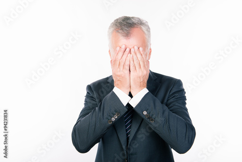 stressful old man in business clothes closed his face hands