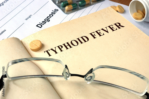 Tableau sur toile Word  Typhoid Fever on a paper and pills on the wooden table.
