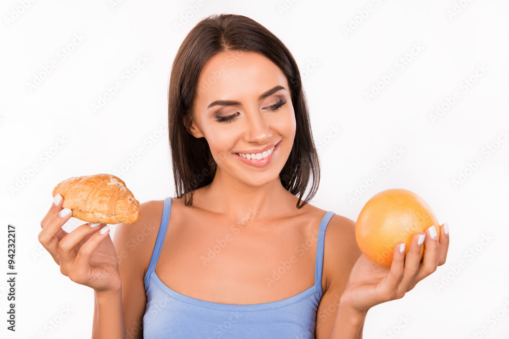 Cute girl chooses between a healthy food and harmful food Cute girl chooses between a healthy food and harmful food