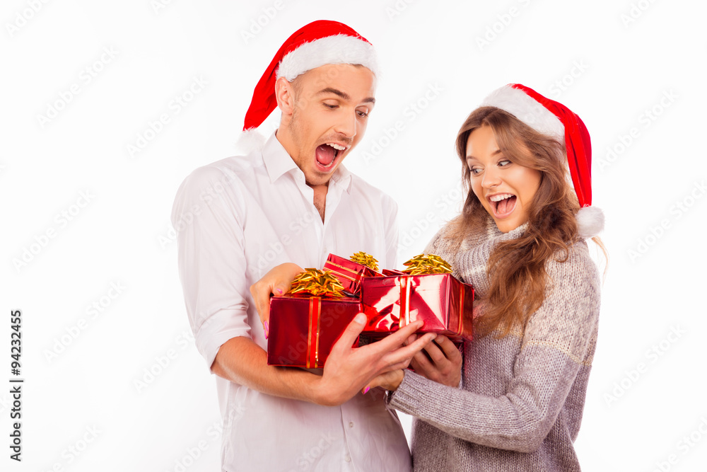 cheerful funny couples with santa hat holding red presents cheerful funny couples with santa hat holding red presents