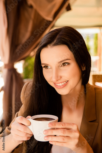 Charming young woman enjoying coffee in cafe