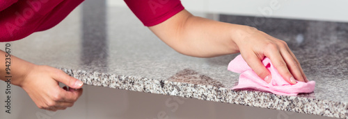Bilde på lerret Woman cleaning countertop