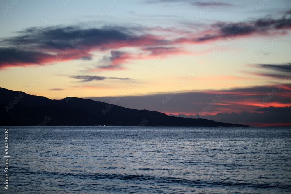 Fototapeta premium Mountain silhouette in sea after sunset