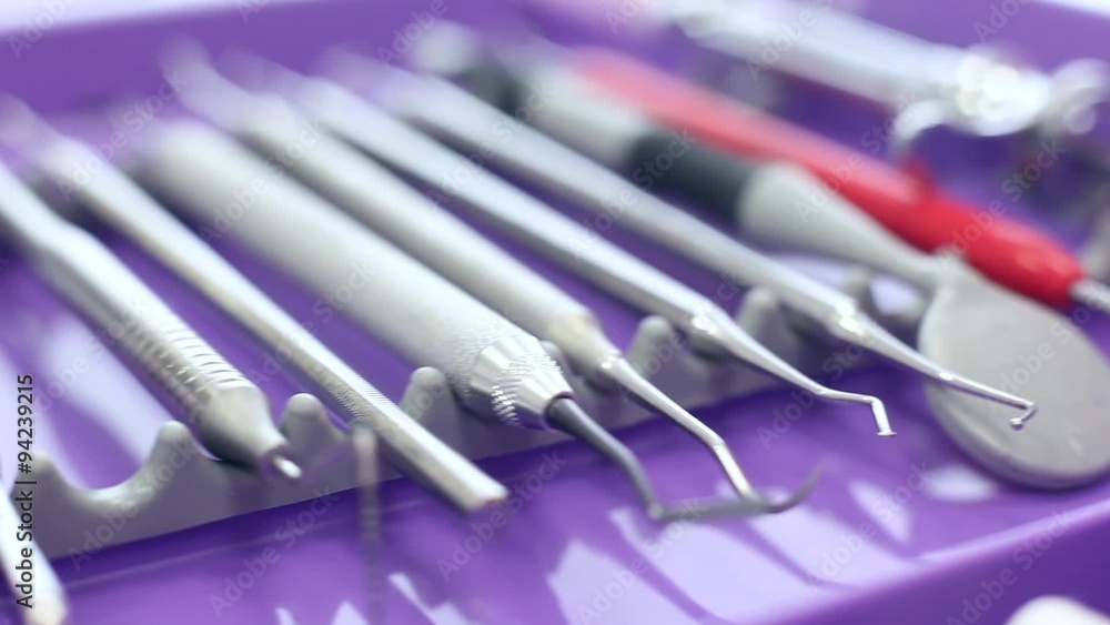 Different dental instruments on a purple tray / camera moving right / close-up