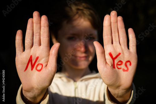 The young girl on the palms of both hands with a red marker says 