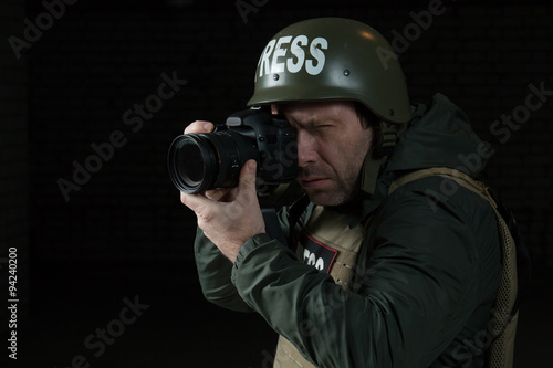 Photojournalist in a helmet and flak jacket wore protective equipment for shooting in hot spot