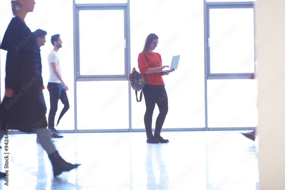 student girl standing with laptop, people group passing by student girl standing with laptop, people group passing by