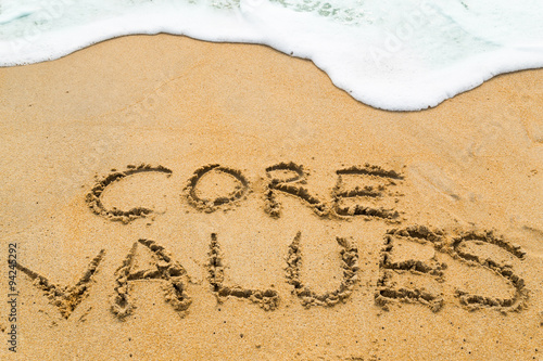 CORE VALUES inscription written on sandy beach with wave approac photo