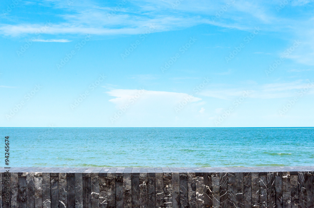 Stone tile wall on sea and sky background Stone tile wall on sea and sky background