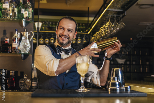 Barman is making cocktail at night club