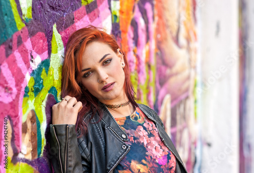 modern urban girl in front of graffiti wall