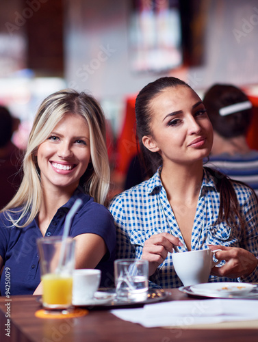 girls have cup of coffee in restaurant