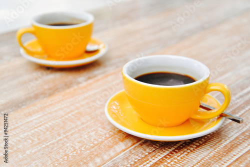 Black coffee in orange cup for two on the table. 