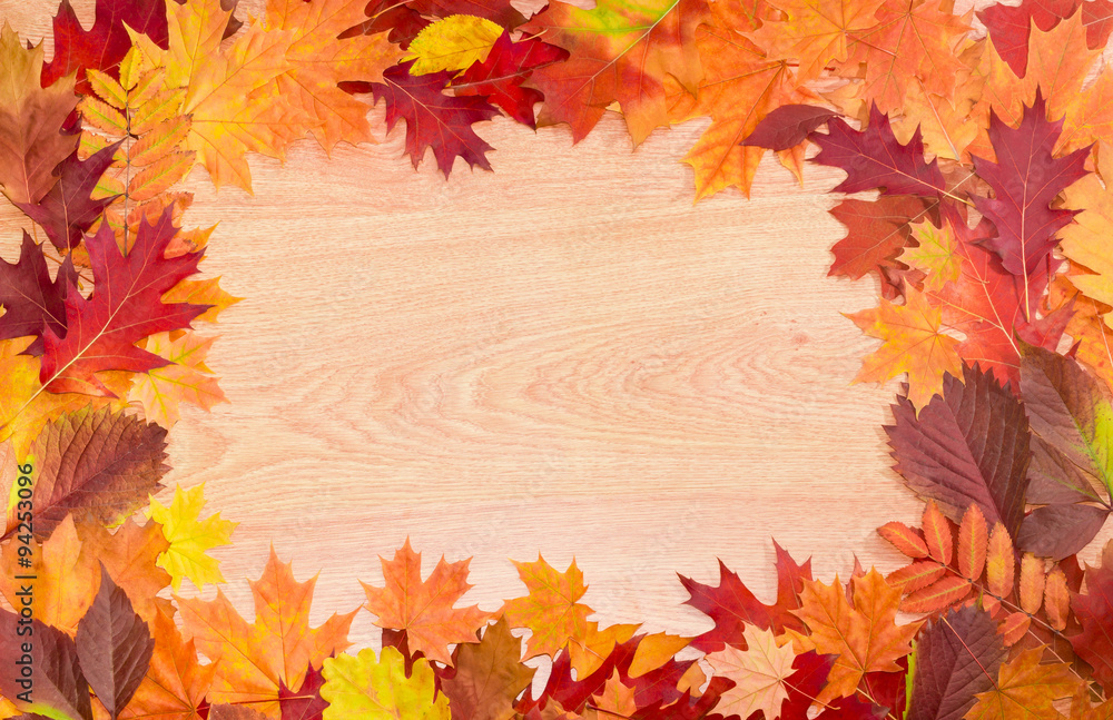 Frame of autumn leaves on a wooden surface Frame of autumn leaves on a wooden surface
