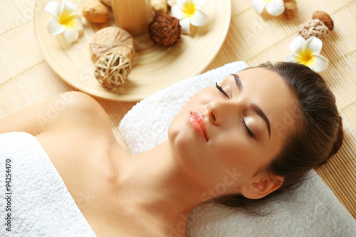 Young woman on massage table in beauty spa salon