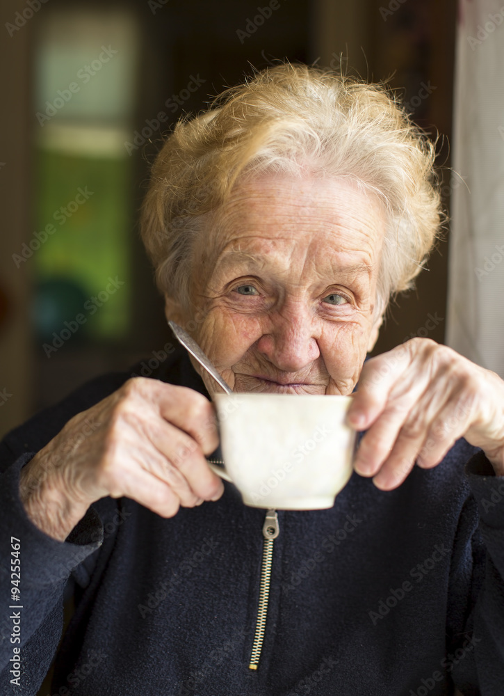 Old woman sits drinking tea, a portrait of an old woman, grandmother. Old woman sits drinking tea, a portrait of an old woman, grandmother.