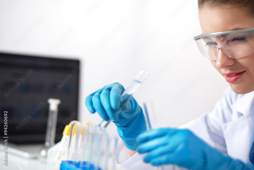 Woman researcher is surrounded by medical vials and flasks Woman researcher is surrounded by medical vials and flasks