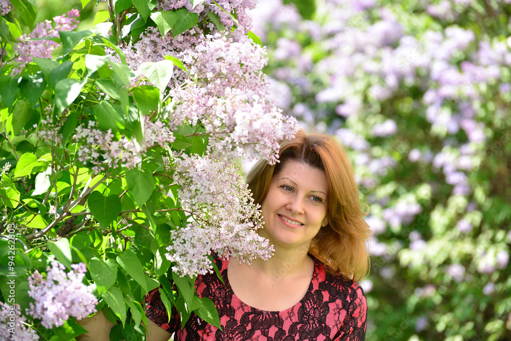 Middle-aged woman near blossoming lilac Middle-aged woman near blossoming lilac