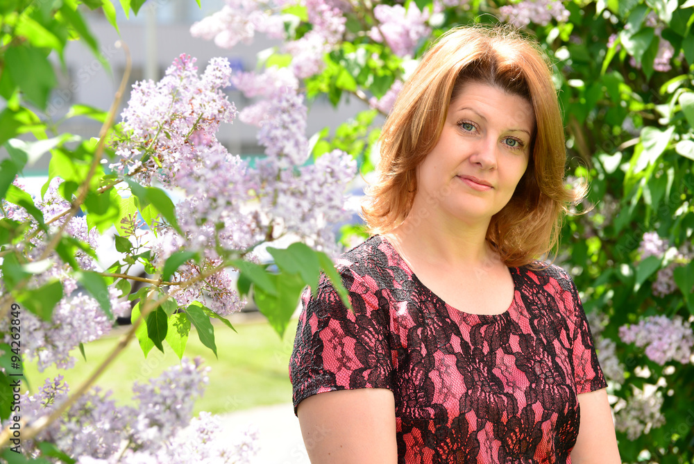 Middle-aged woman near blossoming lilac Middle-aged woman near blossoming lilac