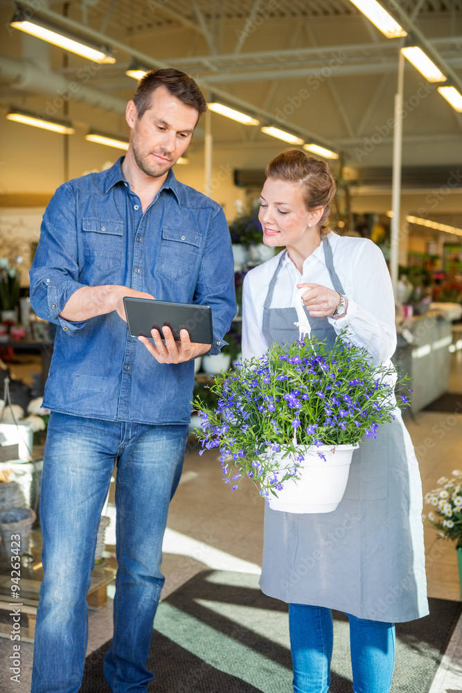 Customer Using Digital Tablet While Standing By Florist
