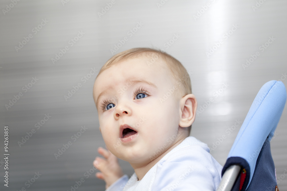 Adorable baby sitting in chair and looking up Adorable baby sitting in chair and looking up