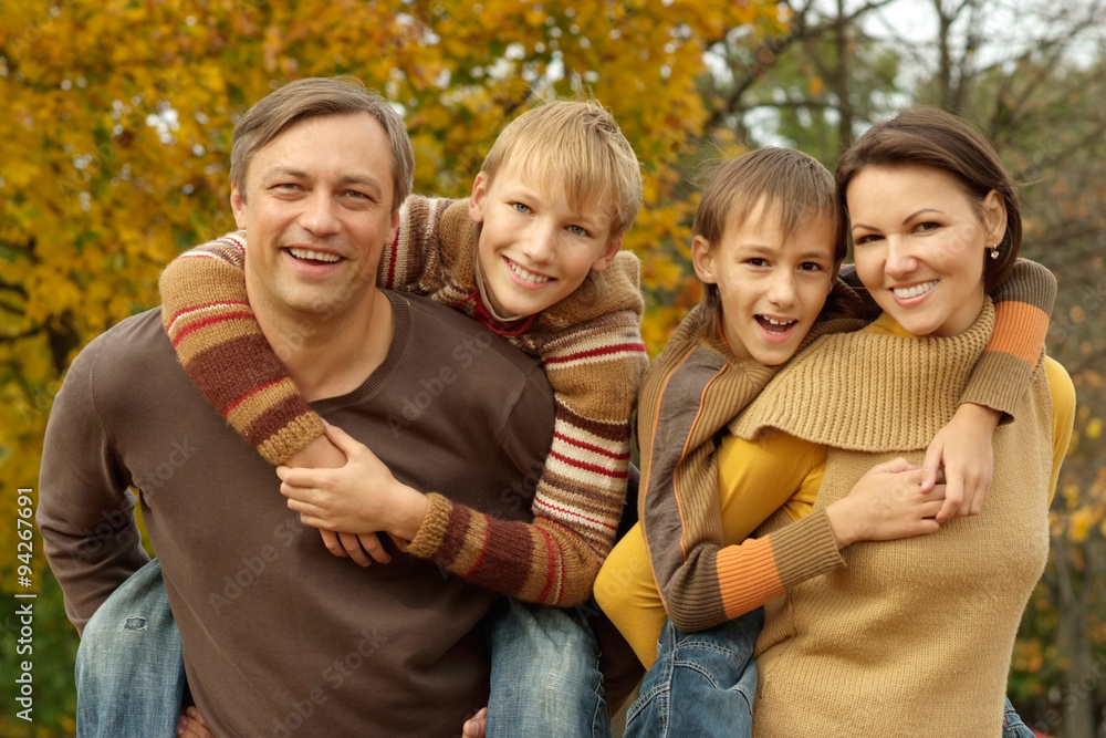 family relaxing in autumn park