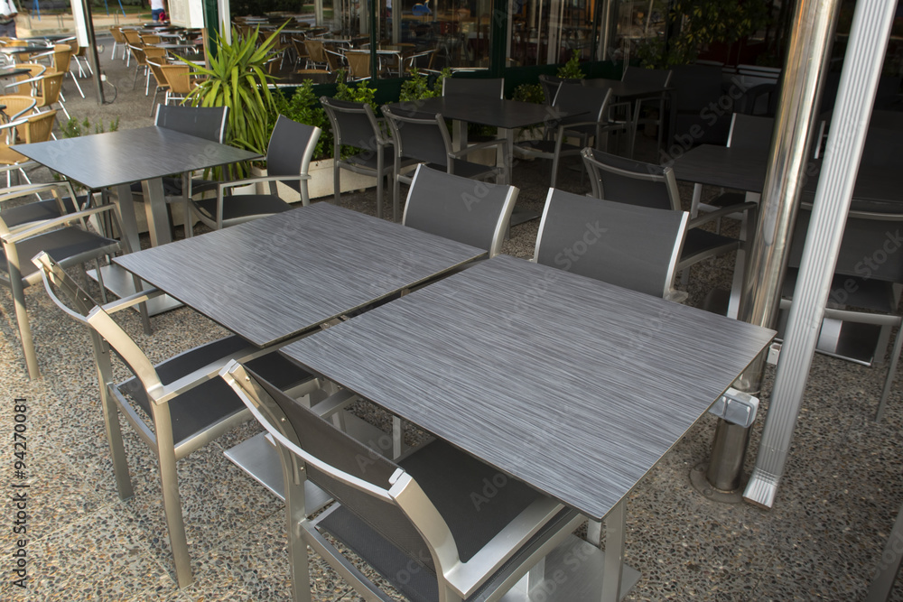 Metal and dark gray stone tables and chairs outdoor of restauran