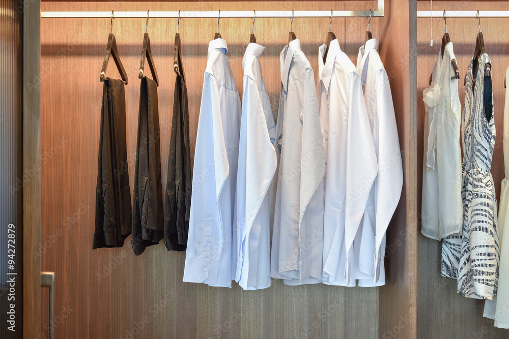 row of white shirts hanging in wooden wardrobe