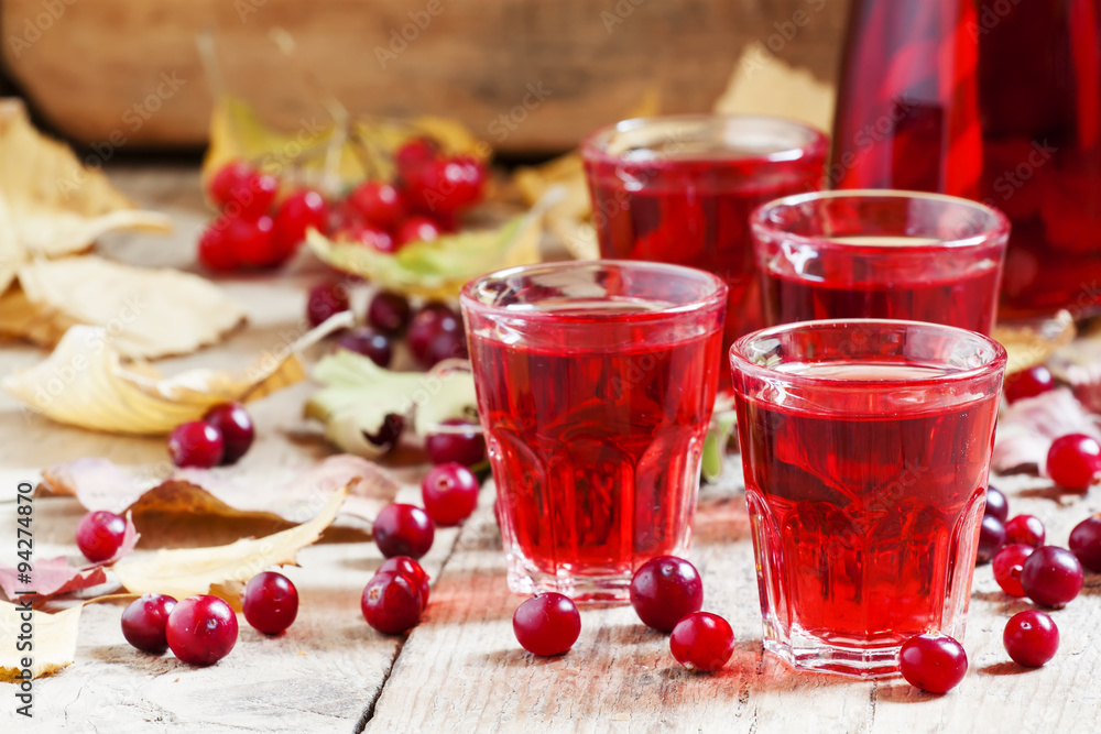 Autumn cranberry cocktail on the old wooden background, selectiv Autumn cranberry cocktail on the old wooden background, selectiv