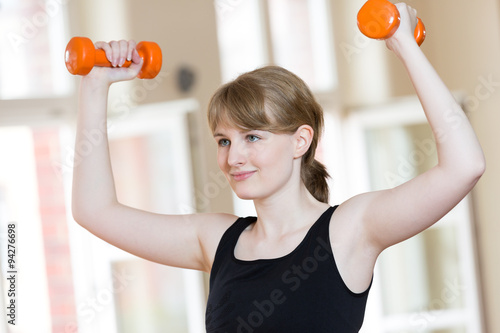 Junge Frau bei Sportübung im Fitnesscenter