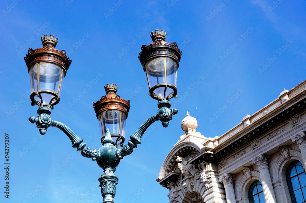 Ornate street light under blue sky in Monaco.